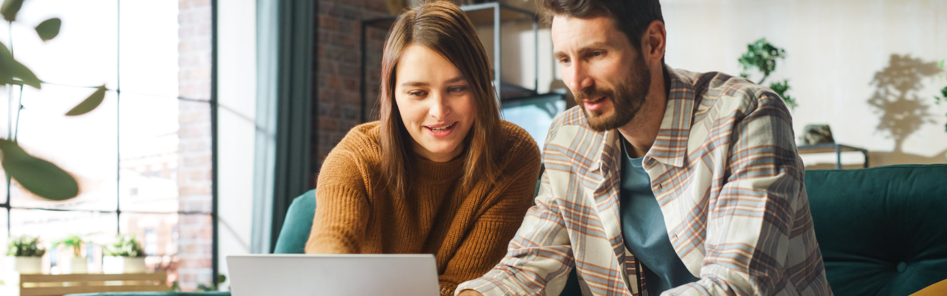 man and woman looking at the laptop